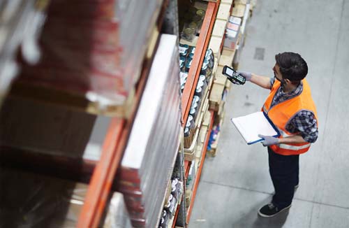 worker standing in large commercial warehouse